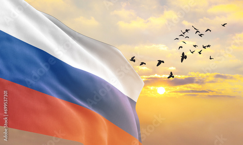 Waving flag of Russia against the background of a sunset or sunrise. Russia flag for Independence Day. The symbol of the state on wavy fabric. photo