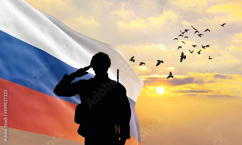 Silhouette of a soldier with the Russia flag stands against the background of a sunset or sunrise. Concept of national holidays. Commemoration Day. photo