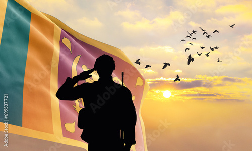 Silhouette of a soldier with the Sri Lanka flag stands against the background of a sunset or sunrise. Concept of national holidays. Commemoration Day. photo