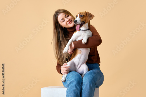 Portrait of cute Beagle on hands of attractive happy smiling young woman. Love and friendship between dog and human. Concept of animal, pet lover, dogfriendly, domestic life, companionship. photo