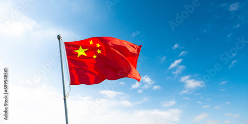 Photography Chinese flag on pole waving in the wind against blue sky