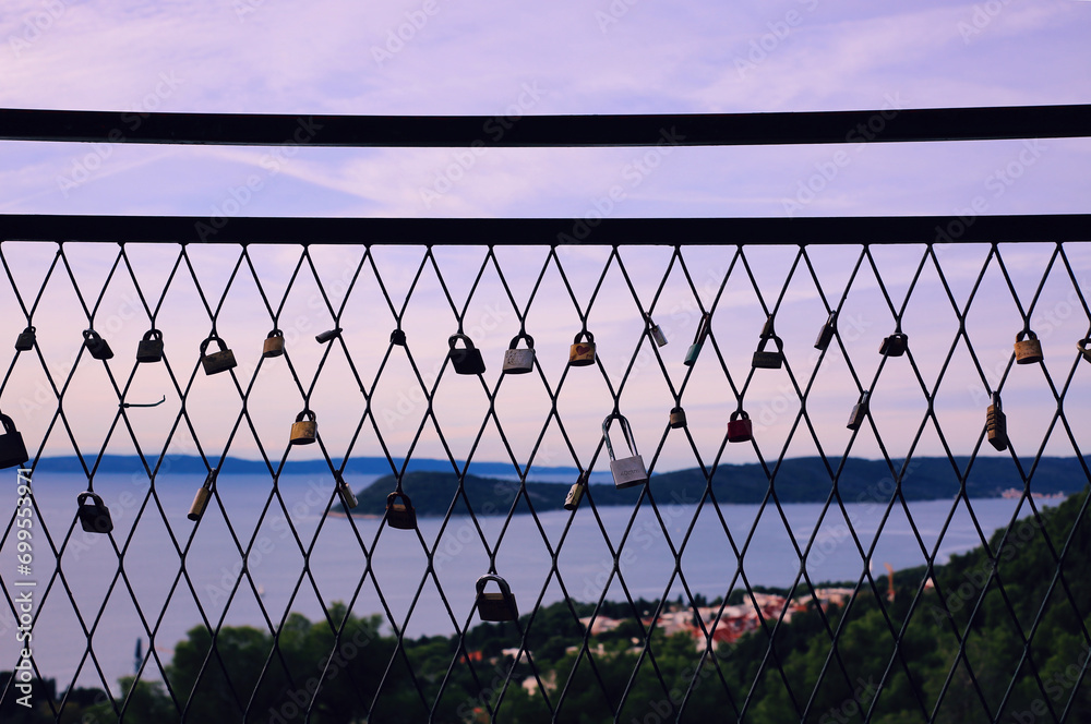 Padlocks on the fence against the background of the sea and sky Padlocks on the fence against the background of the sea and sky