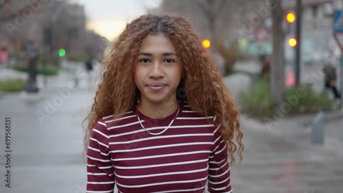 Urban Wanderlust: Confident Young Woman with Afro Hair Strolling through City Streets
