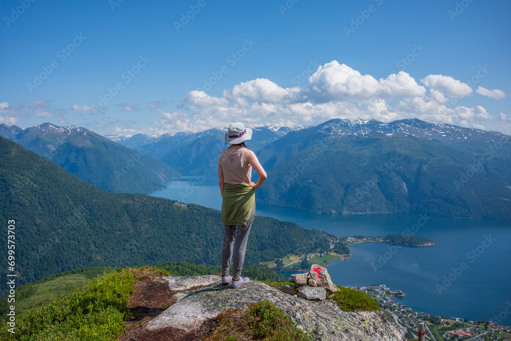 Hikers climb to the summit of Raudmelen peak which overlookis the town of Balestrand on Sognefjord during a summer morning.