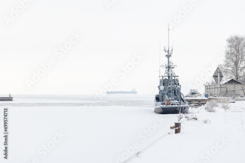 Gray industrial ship is moored in winter port © evannovostro