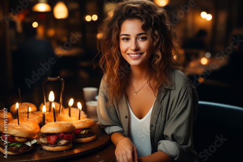 Woman sitting in front of birthday cake with candles.