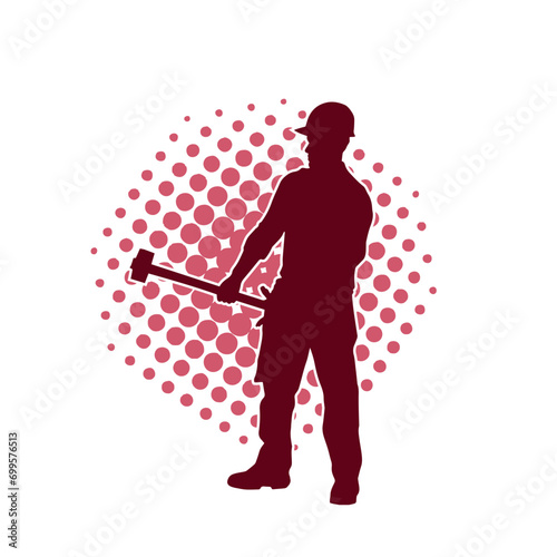 Silhouette of a worker in action pose using his sledge hammer tool.