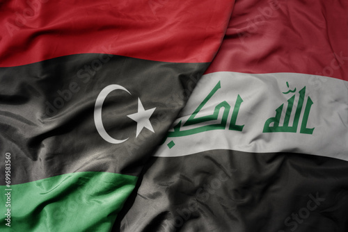 big waving national colorful flag of iraq and national flag of libya .
