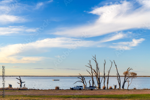 Lake Bonney with dead tree stumps in water at sunset time, Barmera, South Australia photo