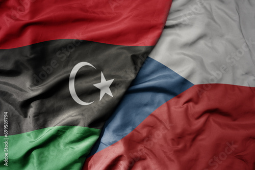 big waving national colorful flag of czech republic and national flag of libya .