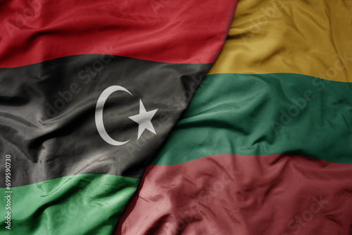 big waving national colorful flag of lithuania and national flag of libya .