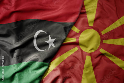 big waving national colorful flag of macedonia and national flag of libya .