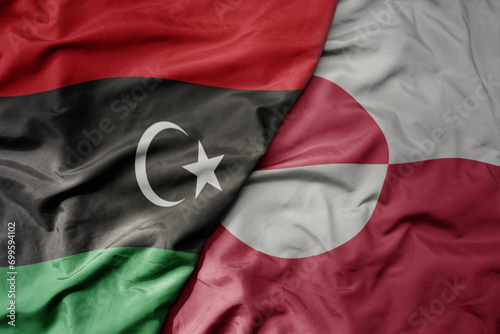 big waving national colorful flag of greenland and national flag of libya .