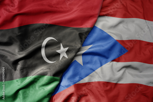 big waving national colorful flag of puerto rico and national flag of libya .