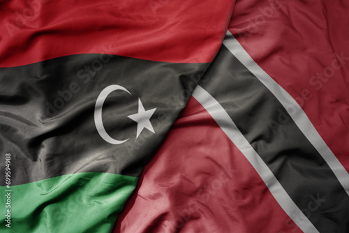 big waving national colorful flag of trinidad and tobago and national flag of libya .