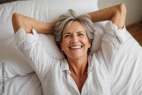 happy mature woman in the morning in bed at home, good carefree morning.