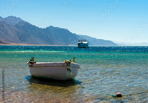 old wooden fishing boat in the sea against the backdrop of the high rocky mountains in Egypt Dahab