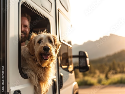 Portrait of smiling young man hugging her dog in the camper van photo