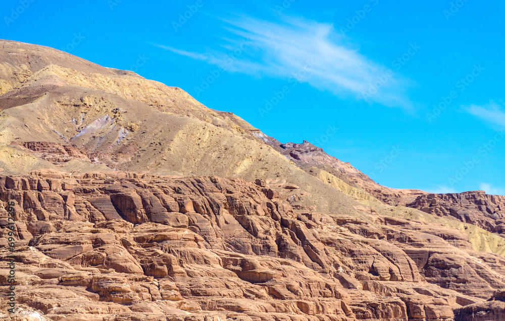 Naklejka premium high rocky mountains against the blue sky and white clouds in the desert in Egypt Dahab South Sinai