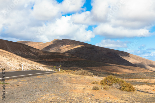 Spectacular view of the volcanic landscape in Timanfaya National Parkwith empty country road. Lanzarote, Canary Islands, Spain, Atlantic, Europe. Tourism and vacations concept.