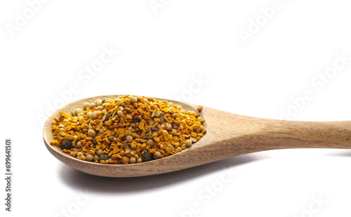 Pile curry spice mix in wooden spoon, turmeric, fenugreek, mustard, coriander, paprika, pepper and cumin isolated on white