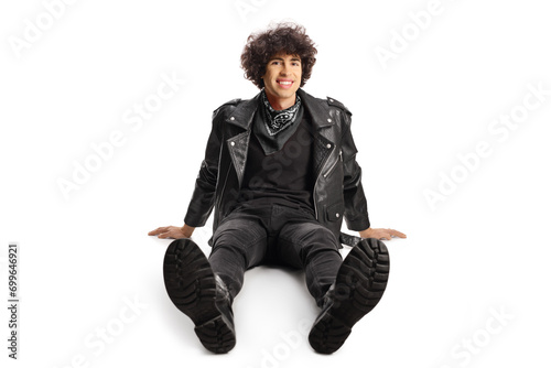 Young man in a leather jacket sitting on ground