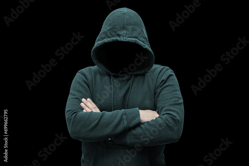 Mysterious faceless hooded anonymous criminal, silhouette of computer hacker, cyber terrorist or gangster on black background