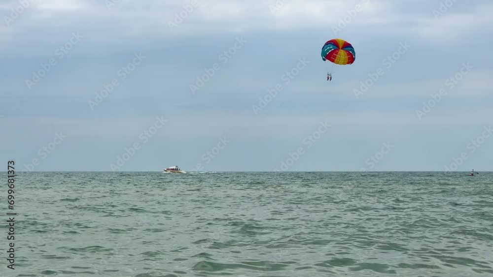 Parasailing: a boat with a marine parachute on the waves. The concept of a cloudy landscape, freedom and summer. Parachutists over the surface of the Black Sea against the sky on a summer day. 4K Parasailing: a boat with a marine parachute on the waves. The concept of a cloudy landscape, freedom and summer. Parachutists over the surface of the Black Sea against the sky on a summer day. 4K