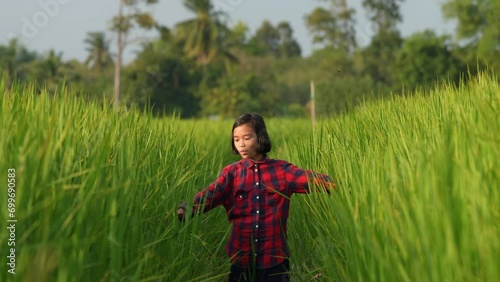 Young Girl in Rice Field: A young girl, lost in a vibrant rice field, explores the endless green landscape, representing the freedom of youth and the beauty of nature.