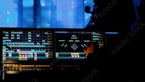 A lighting specialist works at a monitor and control panel for decorations at a festival. photo