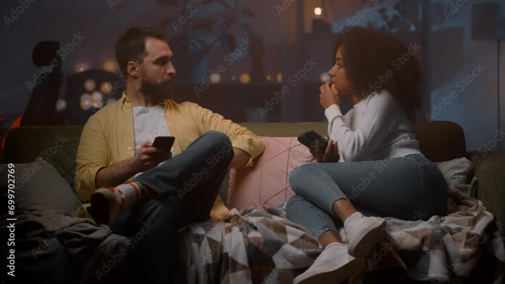 Loving couple talking with digital devices at living room Loving couple talking with digital devices at living room