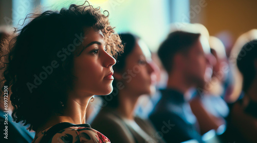 Attentive woman in audience at a lecture or conference. Shallow field of view.