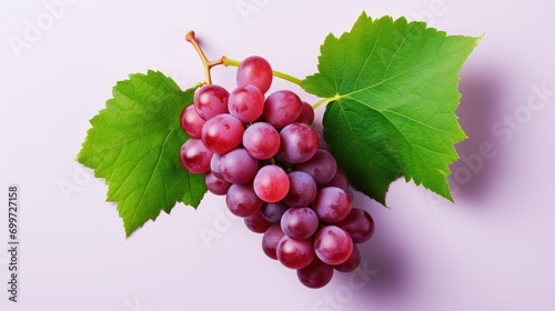 Red grapes with green leaves and half sliced isolated on white background.