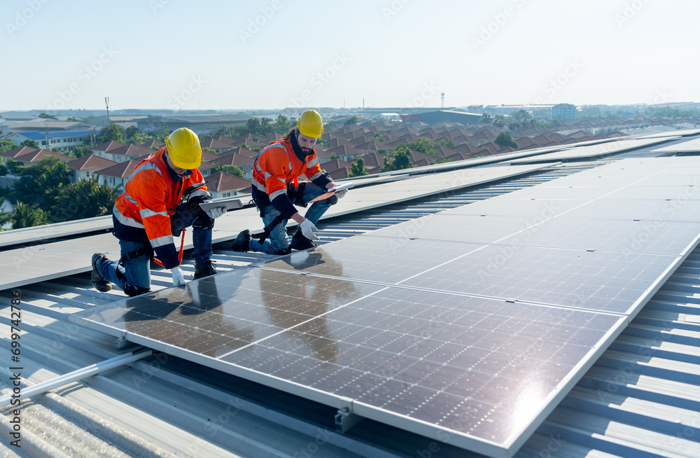 Side view of two Caucasian technician workers check and maintenance the solar cell panels on rooftop of the building or factory. Side view of two Caucasian technician workers check and maintenance the solar cell panels on rooftop of the building or factory.