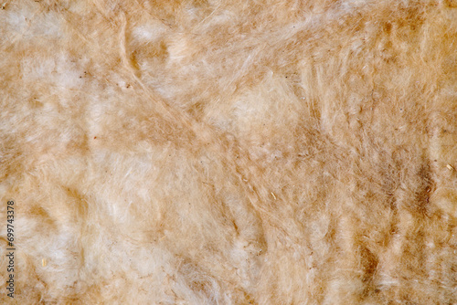 Background of yellow glass wool, texture of insulation material close-up photo