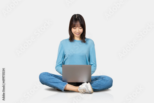 座ってパソコンを使う笑顔の女性