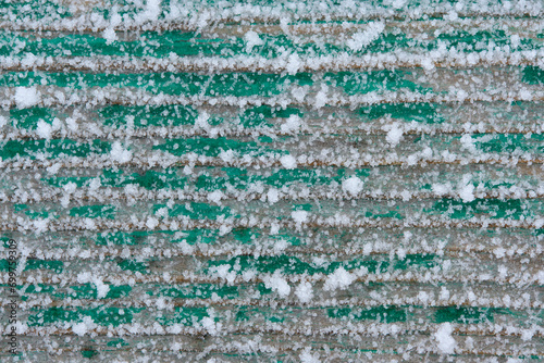 Old boards are covered with snow crystals and frost after severe frosts.
