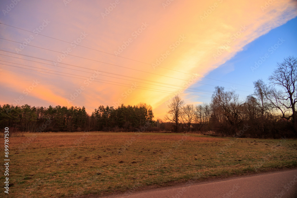 Colourful band of clouds in the morning sky over the fields and meadows of Siebenbrunn, the smallest district of the Fugger city of Augsburg Colourful band of clouds in the morning sky over the fields and meadows of Siebenbrunn, the smallest district of the Fugger city of Augsburg