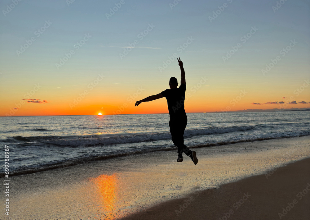 Happy free male tourist traveler at sea or ocean sunset