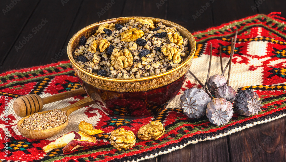 Ukrainian Christmas dish kutia, wheat porridge with nuts, poppy seeds, raisins in a vintage plate on the background of an embroidered towel. Ukrainian Christmas Eve