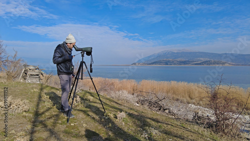 A man birdwatching with a telescope on Lake Egirdir in Turkey. photo