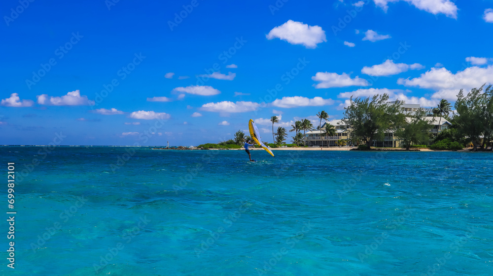 View of the Cayman Islands North Side shore from the pristine blue green turquoise Caribbean sea ocean in Grand Cayman with buildings hotels and greenery plants 