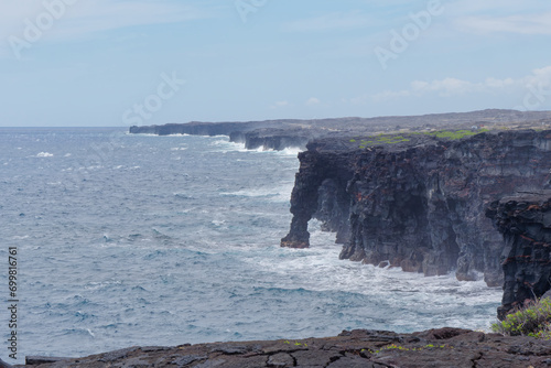 Amazing view of the Hōlei Sea Arch natural bridge of lava cliffs at Volcanoes National Park in Big Island Hawaii photo