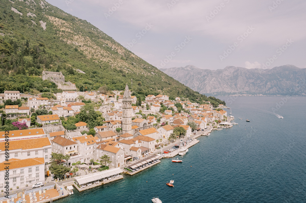 Old stone houses with red tiled roofs on the seashore. Perast, Montenegro. Drone