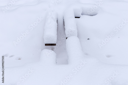 a snowy wooden boardwalk in a forest or swamp