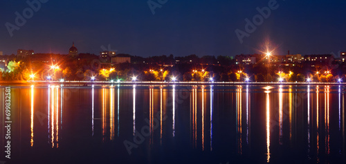 Panorama of the night city with the rays of lanterns and a beautiful reflection in the water. Ternopil, Ukraine