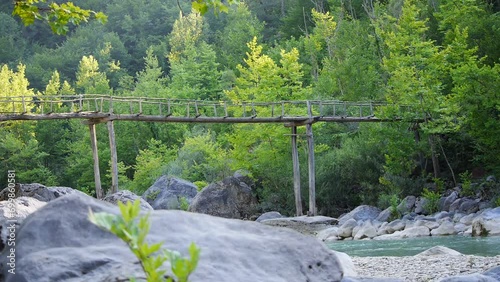 mountain river and bridge in the forest photo