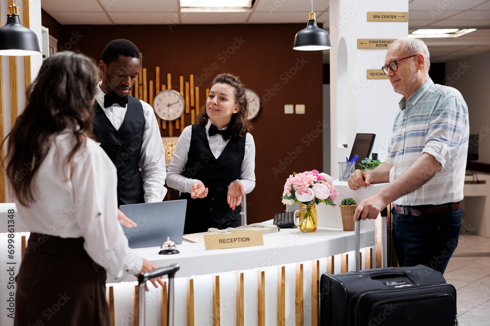 Assisting elderly guests at upscale hotel reception, concierge