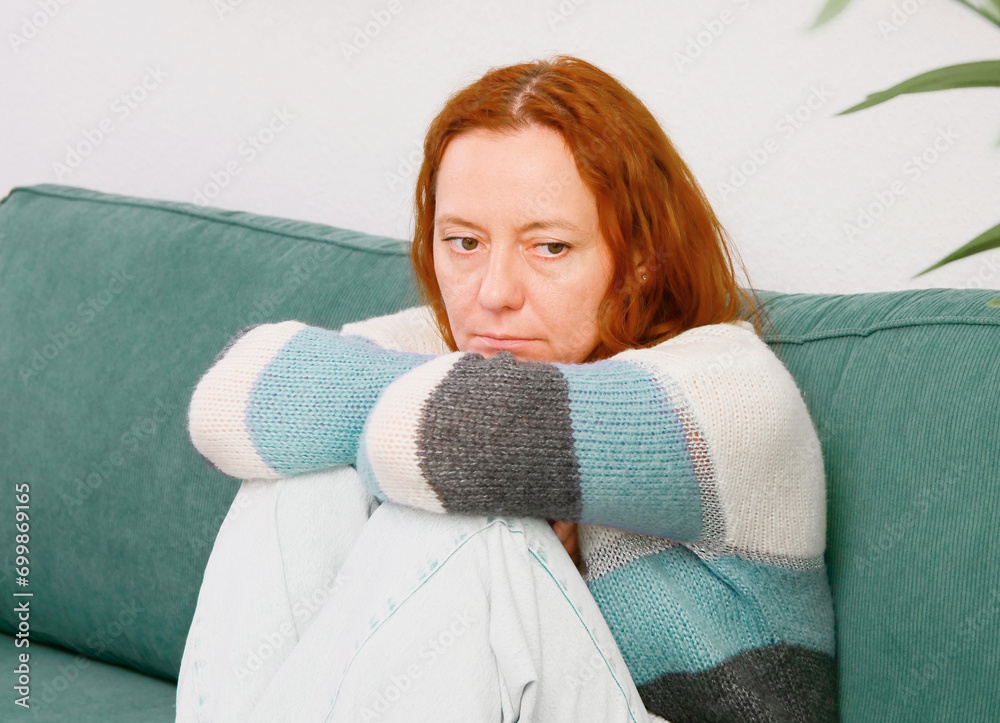 Depression and loneliness. Woman sitting alone on sofa in depressed mood