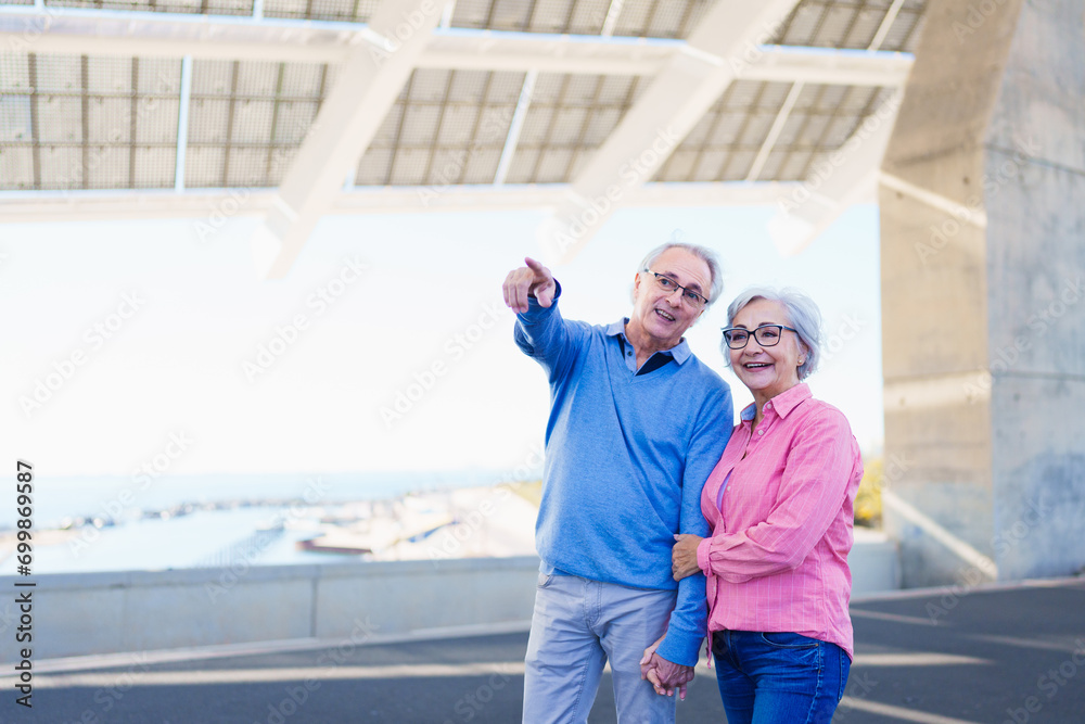 Senior man showing something to his wife while visiting an urban modern space in the city